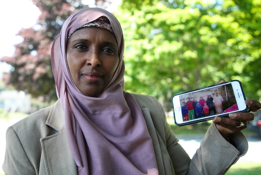 Nasra Gele, a woman of Somali descent who has been living in Halifax since 1997, is working with a private sponsorship group, United We Win Halifax, to sponsor her brother, his wife, and their seven children and bring them to Canada. They have been living in a refugee camp in Kenya for over 20 years. Nasra is seen with a photograph of her brother and his family, in Halifax Friday July 10, 2020.