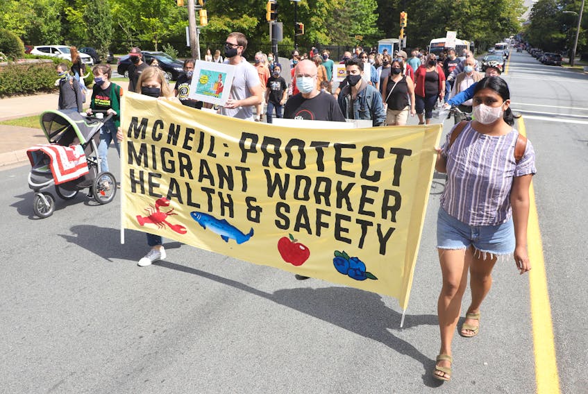 Demonstrators are seen during a Fight for $15 and Fairness rally and march, along Spring Garden Road, in Victoria Park in Halifax Monday.