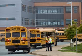 Staff keep track of the dozens of buses arriving with students, for first day of classes at Charles P. Allen High School in Bedford, Tuesday September8, 2020.