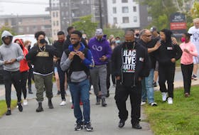 About 50 people turned out this morning to walk Demario Chambers, left, to school at Charles P. Allan, Tuesday, Sept. 8, 2020. The walk was organized to give support to the teen, who was wrestled to the ground during an arrest by police at a Bedford Mall last spring.