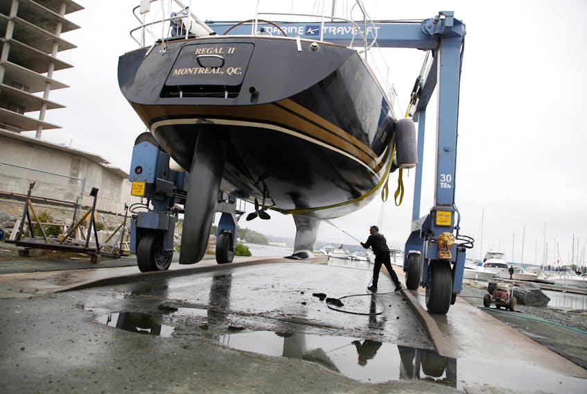 Adrian Beaton uses a pressure washer to clean off the hull of his 41' Tartan, the Regal II, after he had it pulled from the water at the Dartmouth Yacht Club on Friday, Sept. 18, 2020. Beaton said the boat suffered some scuffing during last year's hurricane Dorian and didn't want that to happen again. Forecasts have hurricane Teddy on track to hit Nova Scotia next week. 
TIM KROCHAK PHOTO