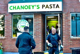 A member of the Halifax Regional Police forensic unit carries out a large rock, following an early morning break-and-enter and theft at Chanoey's Pasta in downtown Dartmouth, Thursday September 24, 2020.