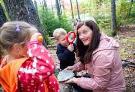 Early childcare educator, Jill Blue, is seen wth some of her young charges with magnifying glasses, in a wooded area near Colby Village Elementary School Friday, Oct.. 2, 2020. Premier Stephen McNeil announced the completion of the implementation of the Nova Scotia pre-primary Program in the playground at the school.
