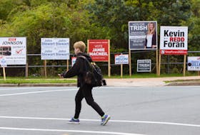 FOR CAMPBELL STORY:
A pedestrian crosses Cumberland Drive, backdropped by an array of signs for some of the candidates running in District 4, in Cole Harbour Wednesday October 7, 2020.

TIM KROCHAK PHOTO