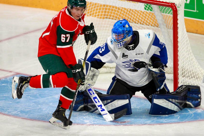 Halifax Mooseheads Sonny Kabatay tries to deflect a shot in front of Saint John Sea Dogs goalie Zachary Bouthillier during QMJHL action Thursday evening at Scotiabank Centre.