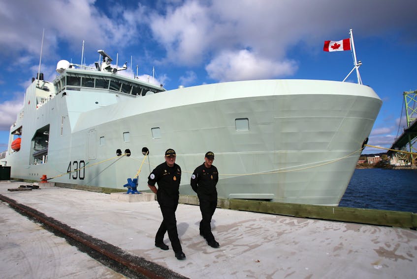 Cmdr. Corey L.E. Gleason, left, the captain of HMCS Harry DeWolf, and Chief Petty Officer First Class Jamie Haas walk alongside the ship at HMC Dockyard in Halifax, Friday, Oct. 23, 2020.