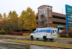 An ambulance drives by on Robie Street past the Halifax Infirmary parkade on Oct. 31, 2019.