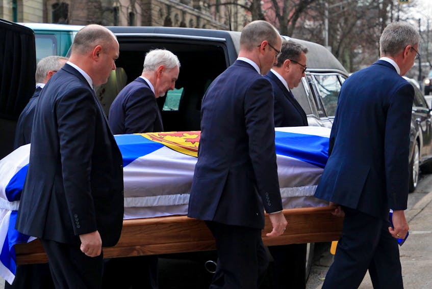 The flag-draped coffin of former Nova Scotia Premier Gerald Regan is brought into St. Mary's Basilica for his funeral in Halifax on Friday.
