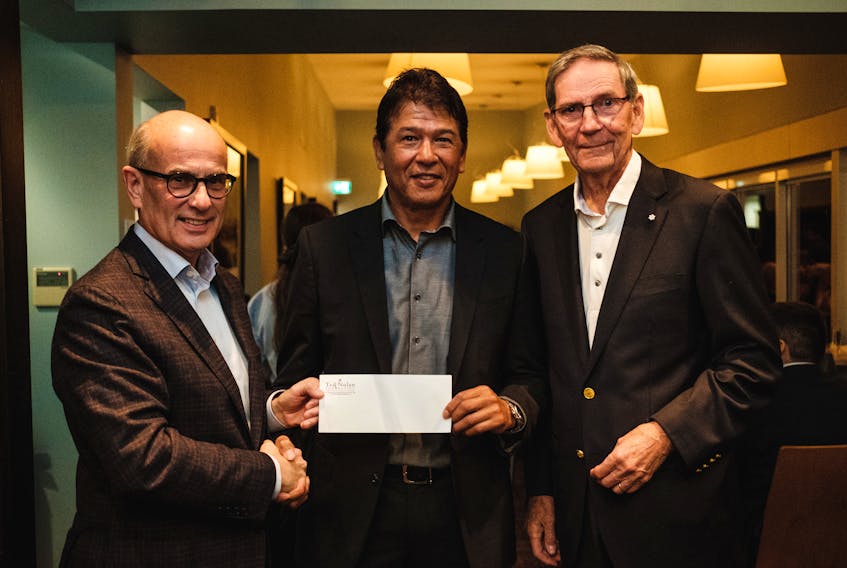 Ted Nolan, centre, is shown presenting Cape Breton University with a cheque for $75,000 to support First Nations women in reaching their educational and training goals. From the left are Cape Breton University President and Vice-Chancellor, David C. Dingwall, Ted Nolan, and Joe Shannon, chair of Cape Breton Island Golf Experience in Support of the Purdy Crawford Chair in Aboriginal Business Studies on October 1, 2018, at Cabot Links, Inverness Nova Scotia.