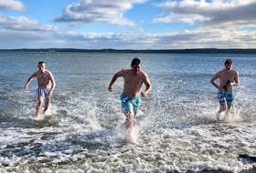 From left, Khoner White, 16, Ethan Murrant, 17, and Jack MacDonald, 17, race out of the icy ocean water at the beach near Port Morien harbour after their dip for the annual polar dip, which has been named a Polar Splash this year due to it's different format. White could be heard yelling, "It's cold," as he ran to his waiting towel and housecoat. NICOLE SULLIVAN/CAPE BRETON POST 