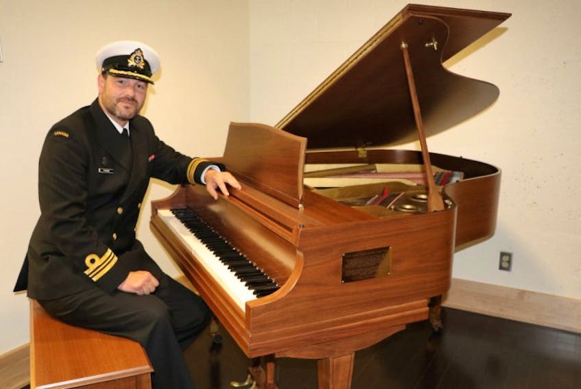 CFS St. John’s commanding officer Lt. Cmdr. Gerry Parsons sits at a historic and restored Wurlitzur baby grand piano in the Argentia Room at the St. John’s base. 