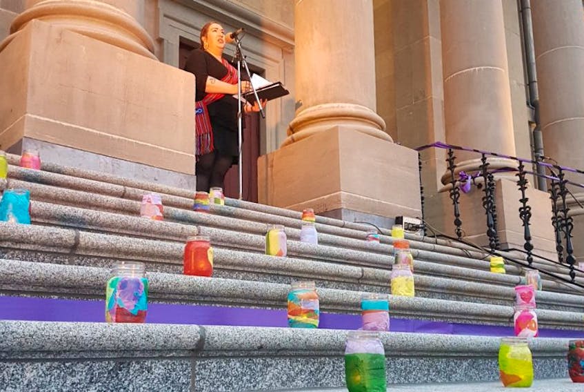 With candles arrayed across the steps of the Colonial Building,  Amelia Reimer, cultural support worker with the St John’s Native Friendship Centre, speaks Wednesday during a vigil for 117 missing and murdered Newfoundland and Labrador women and girls.