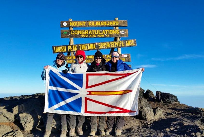 Sisters (from left) Mabel Nash, Lisa McGrath, Laurie McGrath and Jacinta McGrath hold the provincial flag at the summit of Mount Kilimanjaro in Tanzania.