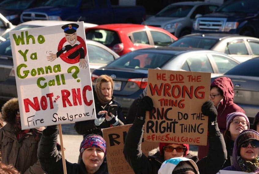 Protesters outside RNC headquarters in St. John’s on Monday display signs urging the firing of Const. Doug Snelgrove.