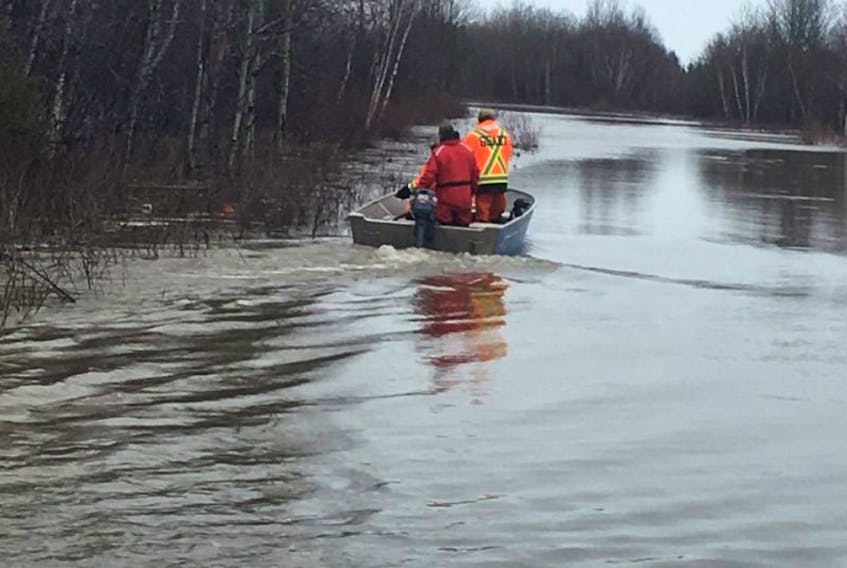 Members of a search and rescue team travel by boat on Mud Lake Road toward the boat launch area as they check on people in the flooded town following the evacuation.