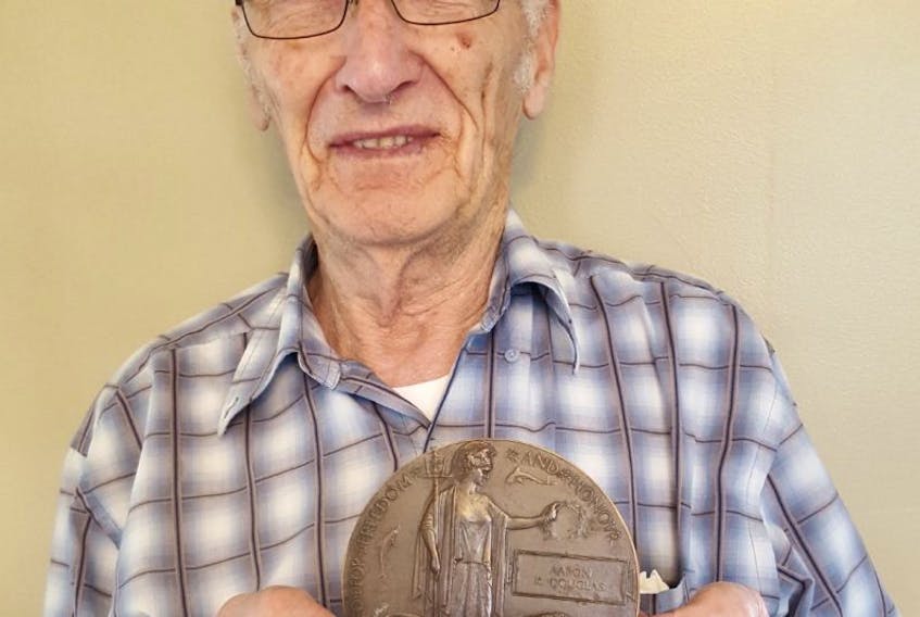 Ralph Douglas holds the “Death Penny” of his uncle, First World War soldier Aaron Keeping Douglas, who was killed near the end of the war. Douglas found the plaque in a box in his father’s attic years ago.