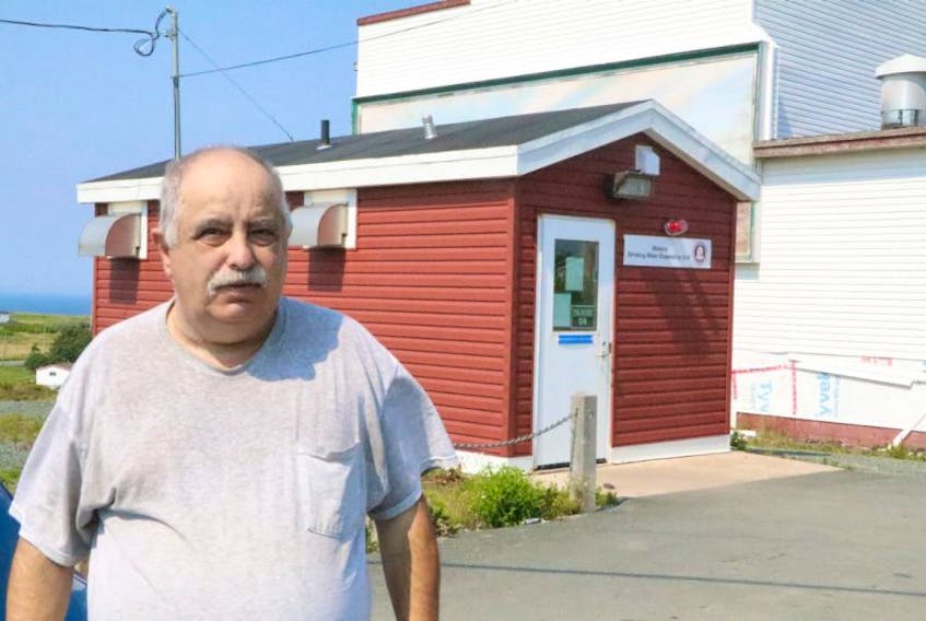 Wabana Mayor Gary Gosine says the Advanced Drinking Water System housed in the burgundy shed behind him belongs to the town, despite a mistake made during the sale of the old firehall (white building) to Beachstone Enterprises Inc.