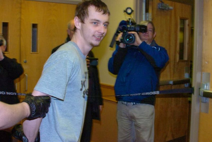 Jesse Lewis smiles at reporters as he’s led to (from) the courtroom at provincial court in St. John’s Tuesday. He’s accused of shooting a man in Avondale.