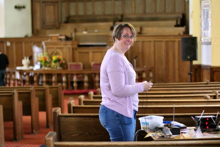 Cochrane Street United Church minister Rev. Miriam Bowlby tests the sanctuary sound system in preparation for Easter Sunday’s service — the first regular service to be held in the building in more than a year.