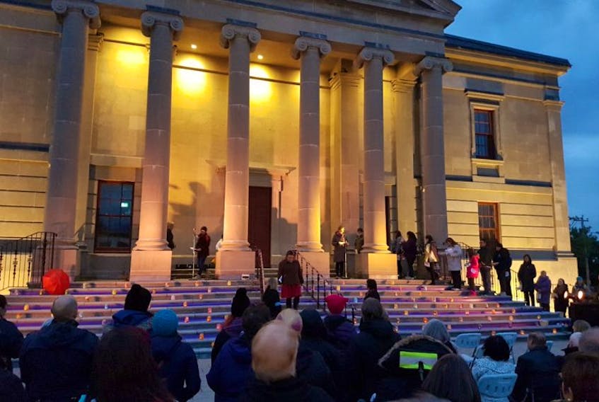 Women and men read the names and biographical details of the 117 missing and murdered Newfoundland and Labrador women and girls during a vigil Wednesday at the Colonial Building in Bannerman Park.