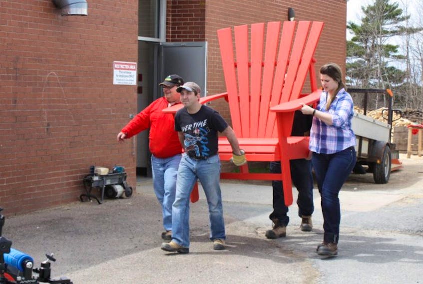 This photo was taken at the beginning of the partnership in spring 2017 at the Corridor Community Options For Adults facility in Elmsdale, N.S. This chair was one of the first chairs to be completed and was ready to wrapped so it could be shipped to a Sobeys store. From left: Dale Dalrymple and Chris Pratt, Woodshop Program participants and Leslie Blois, Site Job Coach.