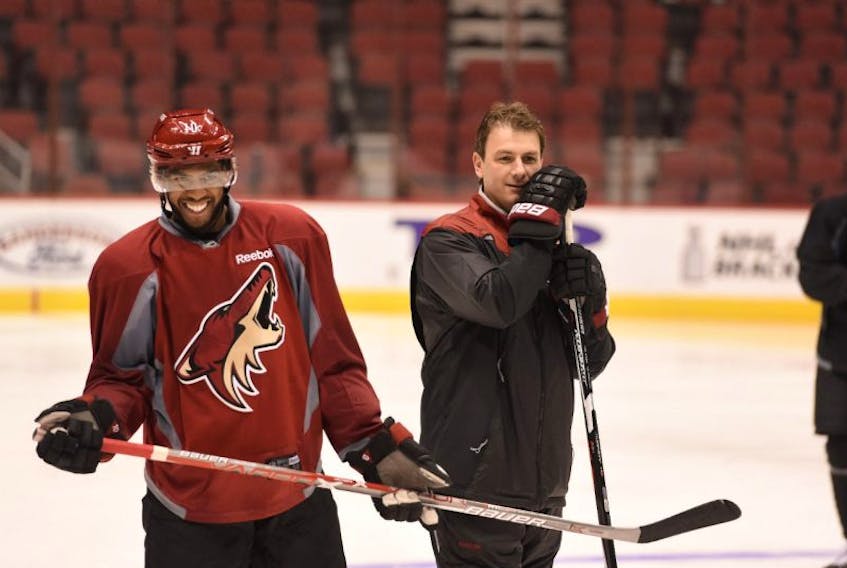John Slaney, shown in this file photo at an Arizona Coyotes practice session with Anthony Duclair (left), could be remaining as a coach in the Coyotes’ system even with the team bringing in a new head coach in Rick Tocchet. However, Slaney might be working in a different capacity.
