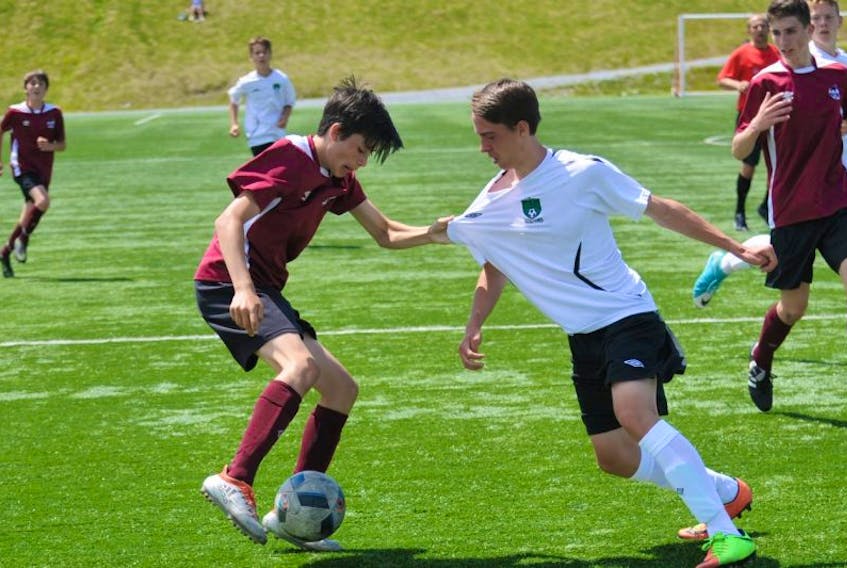 Newfoundland and Labrador’s Taj Exley grabs the jersey of New Brunswick’s Kyle Gould during their opening game in the Atlantic under-14 boys soccer championship at the Wellington Street Complex in Corner Brook on Thursday.