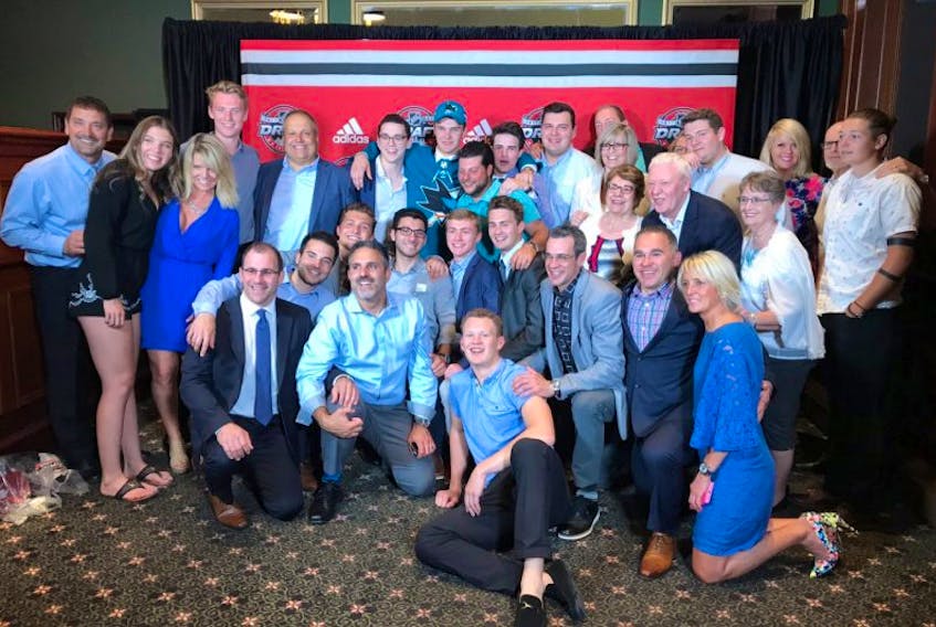 Josh Norris (back row, centre) is surrounded by supporters, mostly members of his family, as they pose for a picture after he was selected in the first round, 19th overall, by the San Jose Sharks in Friday’s NHL Entry Draft in Chicago. Norris’s father, Dwayne (kneeling, far left), had a far different draft experience in 1990 when he was a seventh-round pick of the Quebec Nordiques. Dwayne Norris was fishing on the Gander River when that draft was proceeding and he didn’t find out until a day or more later that he had been taken by the Nordiques.