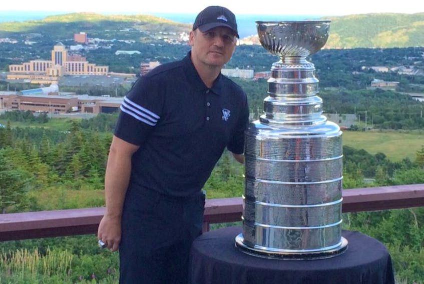 Derek Clancey poses with the Stanley Cup at the Admiral’s Green golf clubhouse in Pippy Park Wednesday, with his native St. John’s in the background.