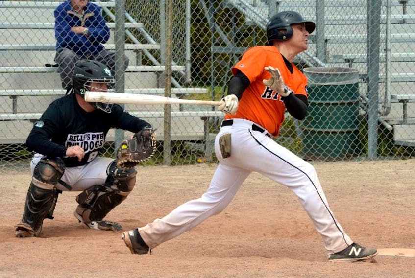 Ward Gosse of the NTV Hitmen swings through a pitch from Sean Cleary (not shown) to Kelly's Pub Bulldogs catcher Blair Ezekiel (8) during their semifinal game in the St. John’s Day senior softball tournament at Lions' Park Sunday afternoon.




