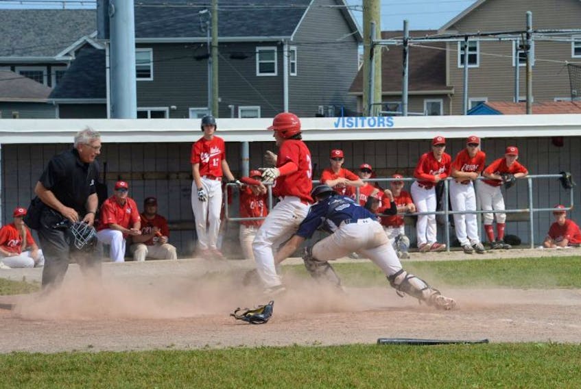 Mount Pearl Blazers catcher Nick French applies the tag to the St. John’s Capitals’ Daniel Rice at home plate as Rice attempted to score on a fielders choice play during the fourth inning of their preliminary-round game in the provincial junior baseball tournament at the Smallwood field in Mount Pearl on Saturday afternoon. Waiting to make the call is home plate umpire Carl Lake. St. John’s won the game 5-4. The Blazers and Capitals would go on to meet in Sunday’s final, with St. John’s prevailing 10-5.