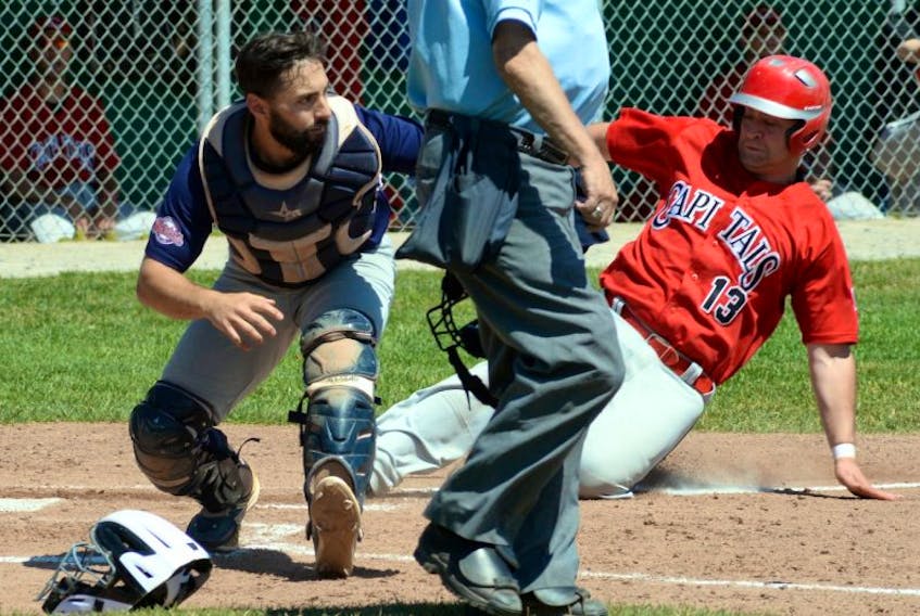 Scott Stockley of the St. John’s Capitals slides safety into home plate, as Corner Brook Barons catcher Steve Sheppard waits for the throw in Game 4 of the Molson provincial senior baseball championship Saturday at St. Pat’s Ball Park. The Caps won the series Sunday in six games, making it four straight provincial titles.