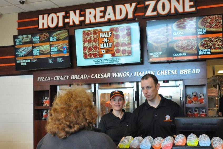 Melissa and Jeff Horner greet one of their first customers on opening day at their Little Caesars franchise on White Rose Drive in St. John’s, the first of its kind in the province.