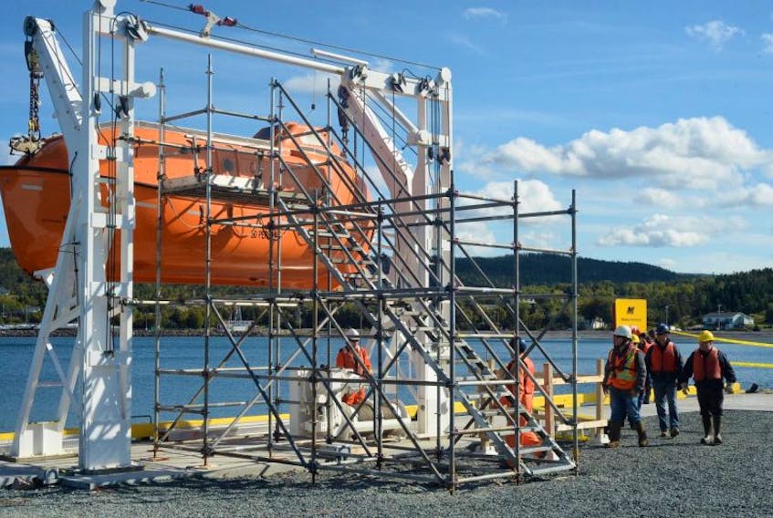 Workers at the Marine Institute’s Holyrood Marine Base secure a lifeboat located at the newly completed wharf.