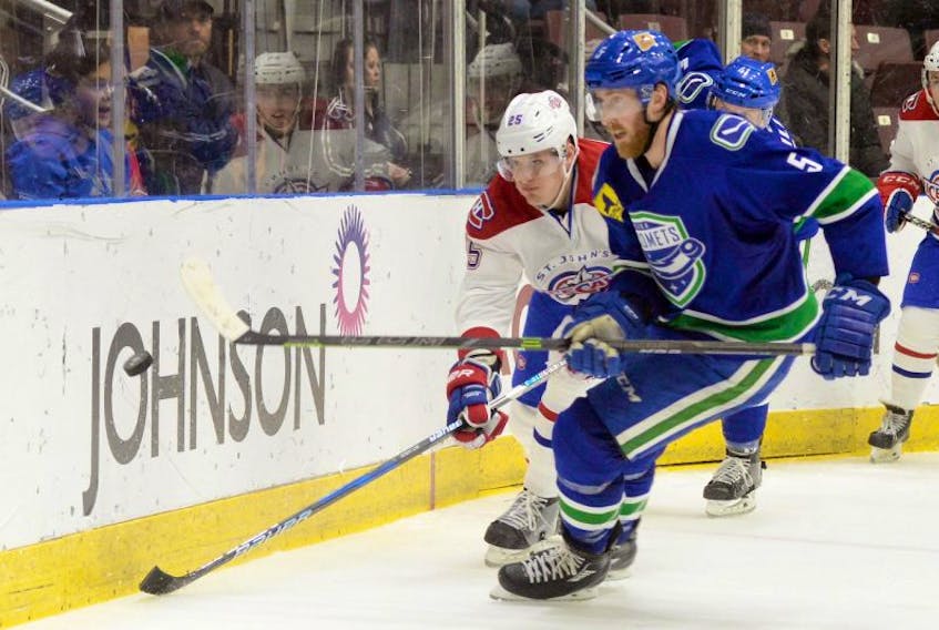 St. John’s IceCaps’ centre Michael McCarron (left) and the Utica Comets’ David Shields chase the puck behind the IceCaps’ net during AHL action at Mile One Centre Tuesday night. McCarron had two assists in his first game with the IceCaps after being re-assigned by the Montreal Canadiens, but Utica won 5-2.