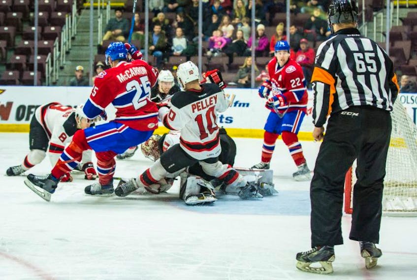 St. John’s IceCaps centre Michael McCarron (25) and Albany Devils captain Rod Pelley take a tumble as Albany goaltender covers up the puck during weekend AHL action at Mile One Centre. The IceCaps’ Chris Terry (22 ) and referee Nick Gill look on.
