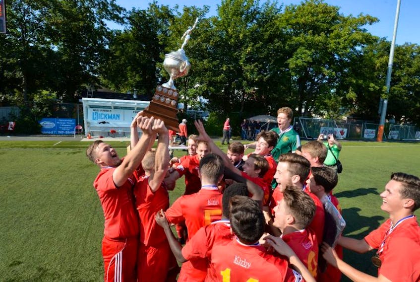 Members of the Holy Cross Kirby Group team celebrate their Challenge Cup championship soccer win at King George V Park Sunday afternoon.