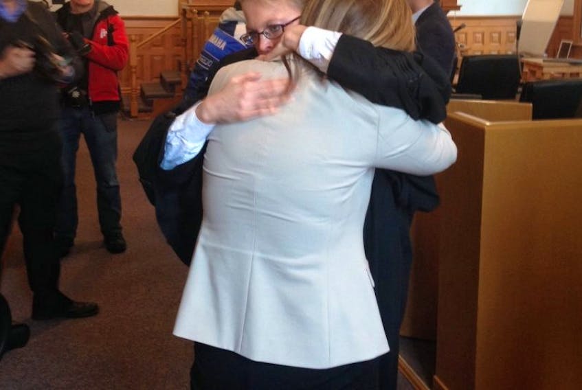 Crown prosecutor Dana Sullivan hugs a woman - whose daughter was sexually assaulted by Reg O'Keefe over 10 years ago - after O'Keefe was sentenced to five years in jail for sexually assaulting four girls decades ago.