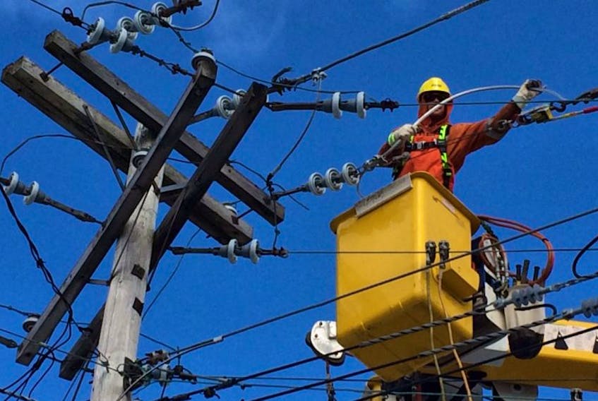 ["Newfoundland Power employee David Drover hooks up power to the area of Hamilton Avenue of St. John's on Sunday morning.\n"]