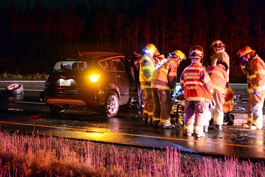 The driver of a car is placed on a stretcher to be taken to hospital early Friday morning.