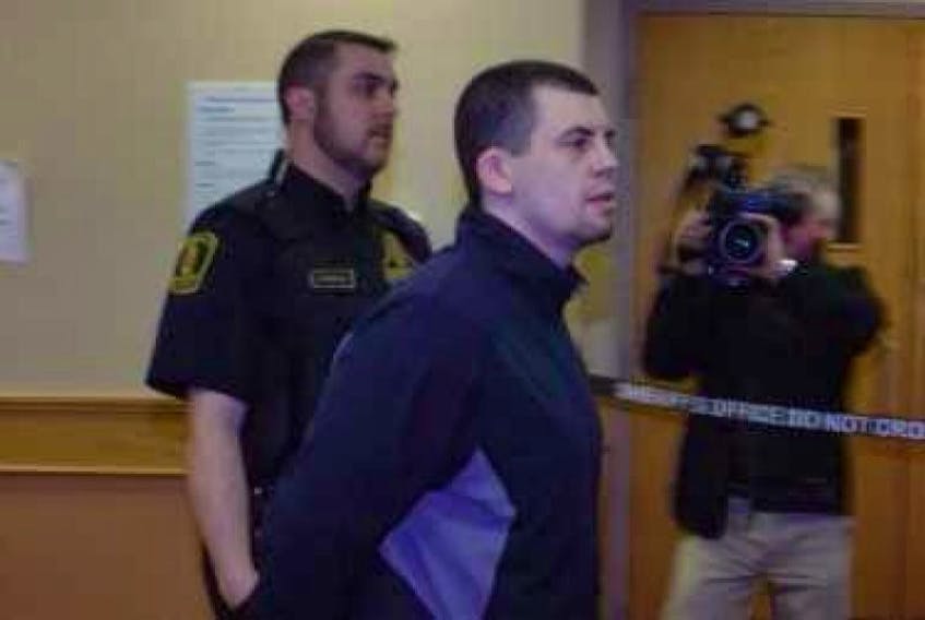 ["Justin Michael Jordan (aka Hussey) is led past reporters on the way out of the courtroom at provincial court in St. John's Thursday. Jordan is accused of trying to kill accused murderer Trent Butt while the two were at Her Majesty's Penitentiary last week."]