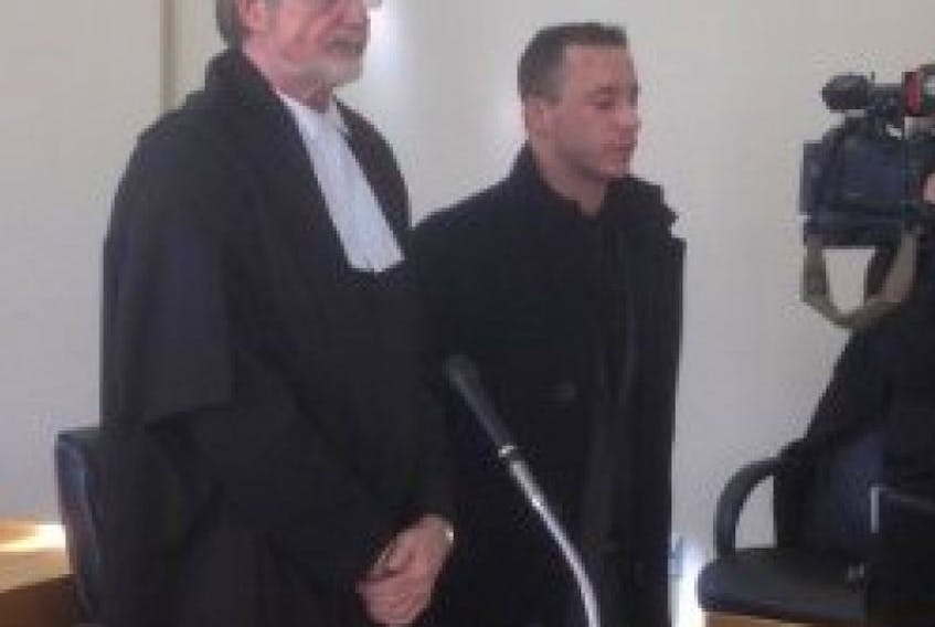 RCMP officer Cameron D. Lockhart (right) and his lawyer Nick Avis stand as the judge enters the courtroom at Newfoundland Supreme Court in St. John's today (Friday).