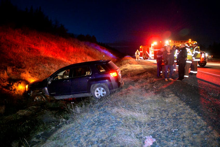 An SUV sits in a ditch Friday night after the driver swerved to avoid hitting a moose.