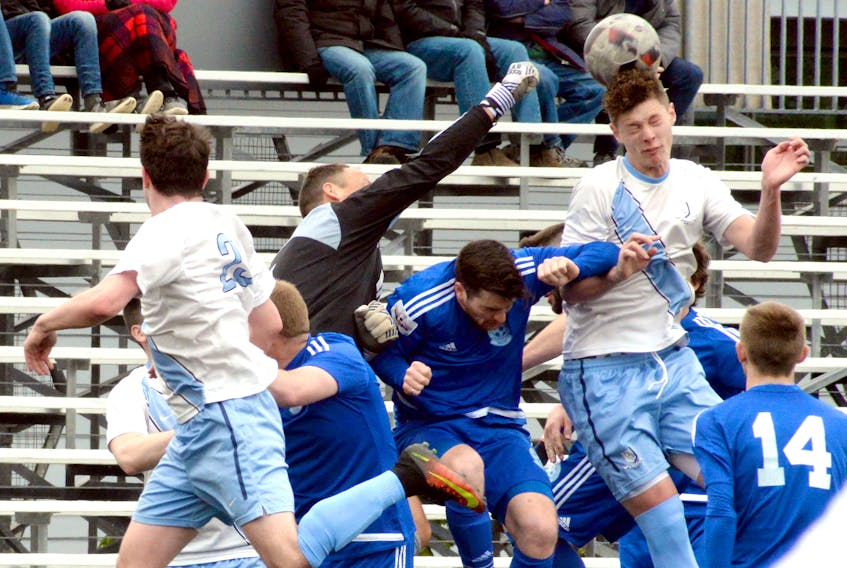 St. Lawrence Laurentians goalkeeper John Douglas (in black) punches the ball away from the netl amid a swarm of Laurentians (in dark blue) and Feildians players during Challenge Cup soccer action at King George V Park in St. John's on Sunday afternoon. Feildians won 4-1.