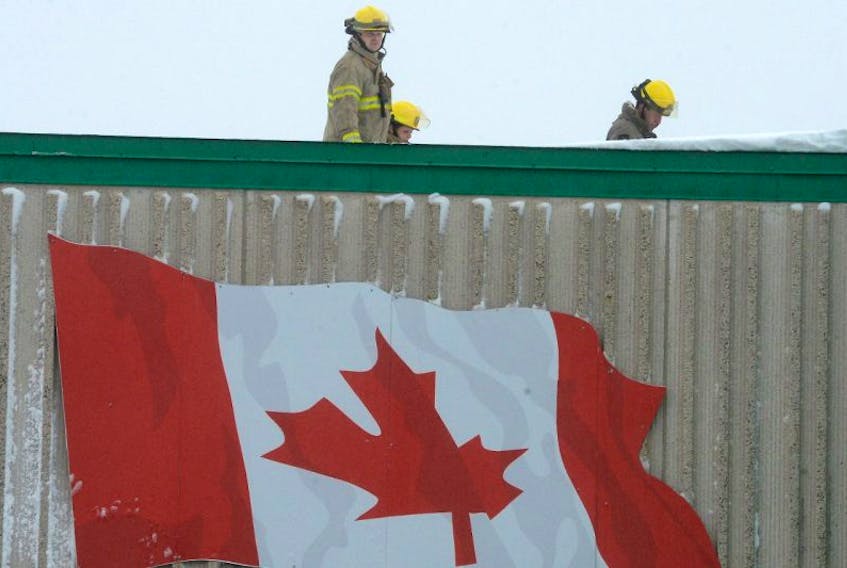Firefighters from the St. John's Regional fire department investigate rooftop ventilation units on the roof of the Kent store on Stavanger Drive Sunday afternoon.