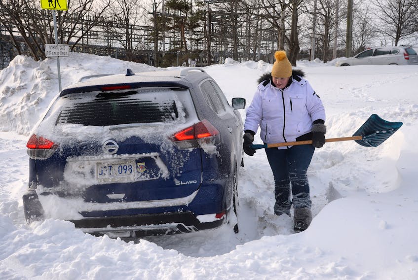 Amanda Kelly begins the task of digging out her car Sunday after it became stuck during Friday’s record-breaking storm. Keith Gosse/The Telegram