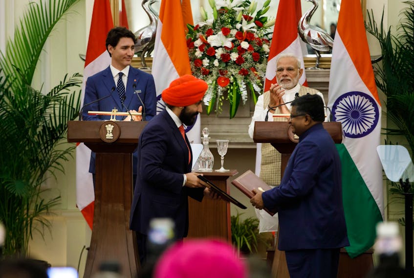 Prime Minister Justine Trudeau (left) and India's Prime Minister Narendra Modi look on as officials exchange documents in this photo from Trudeau's Twitter account.