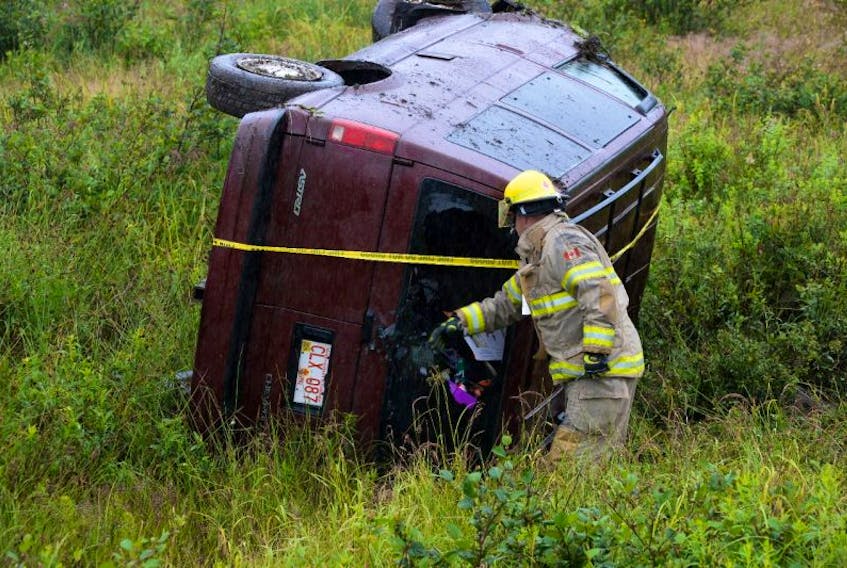 A firefighter with the St. John's Regional fire department secures a vehicle that rolled over after it left the TCH Sunday afternoon. The driver wasn't injured.