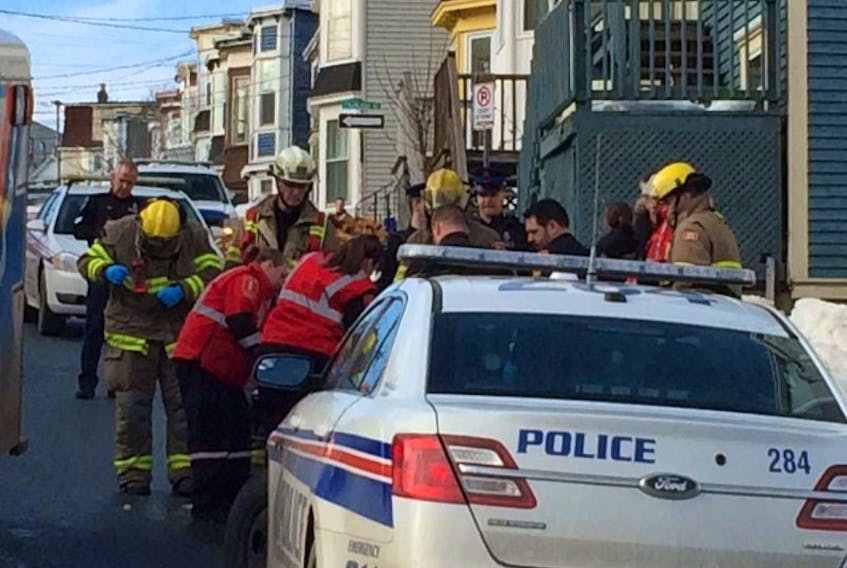 Paramedics, firefighters and members of the RNC surround a person taken from a house on Springdale Street in St. John's. One man was taken to hospital with a gunshot wound and two people were arrested..