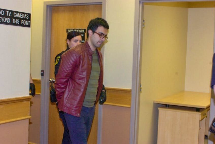 Masih Allahbakshi is led out of the courtroom in provincial court in St. John's Monday after he appeared before a judge on a charge of attempted murder.